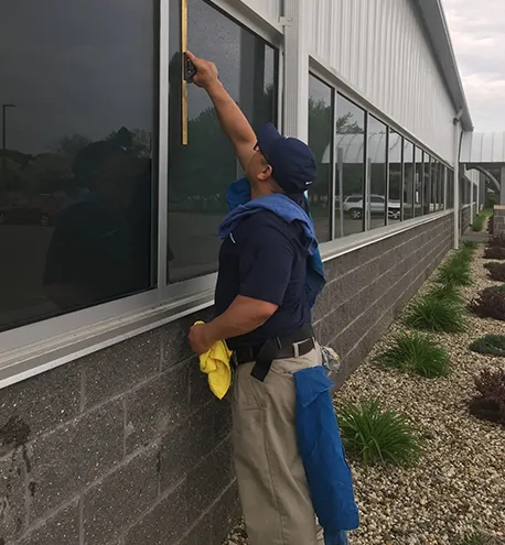Commercial window cleaner cleaning exterior windows of an office building.