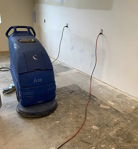 VCT floor stripping machine removing old wax and finish from a commercial floor.