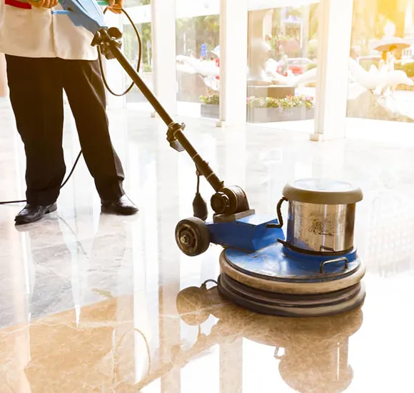 Professional using a floor buffer on a shiny floor in Lansing MI.