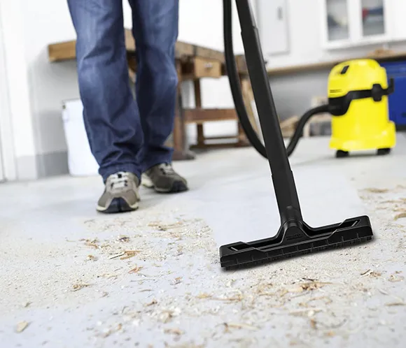 Close-up of vacuum cleaner on dusty floor during post construction cleanup in Ann Arbor MI.