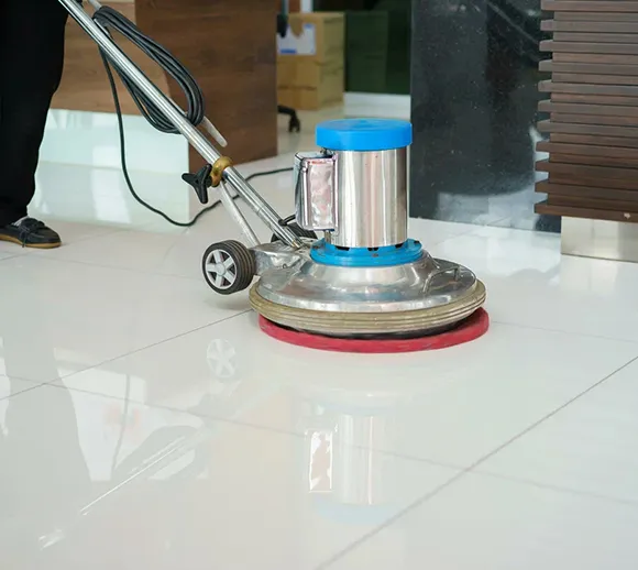 Professional using a floor buffing machine on a tiled floor in Lansing MI.