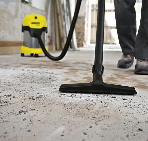 Professional vacuuming debris from a hard floor during post construction cleanup in Lansing MI.