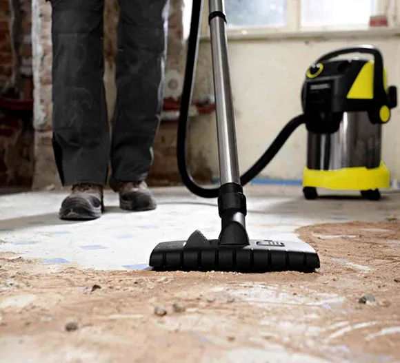 Vacuum cleaner on a floor with debris during post construction cleaning in Detroit MI.