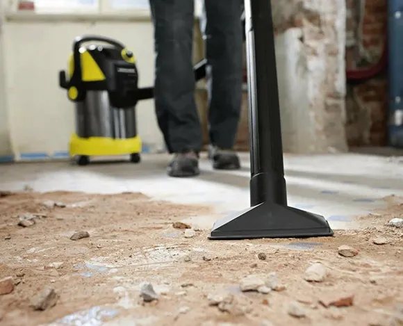 Professional vacuuming debris from floor during post-renovation cleaning in Lansing MI.