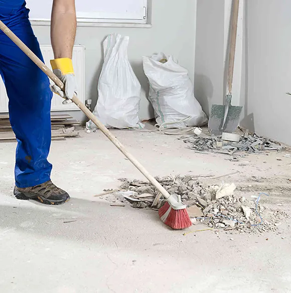 Worker sweeping debris at a construction site in Grand Rapids MI.
