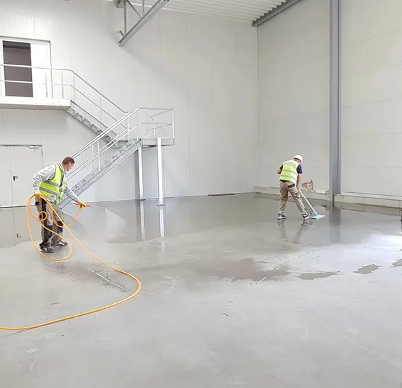 Workers performing post-construction floor cleaning in a large commercial space in Detroit MI.