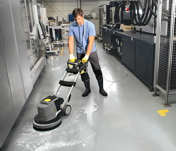 Cleaner using a floor buffing machine for commercial floor refinishing in Lansing MI.