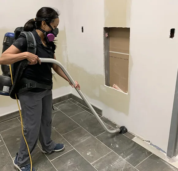 Worker vacuuming floor before epoxy floor cleaning and polishing in Lansing MI.