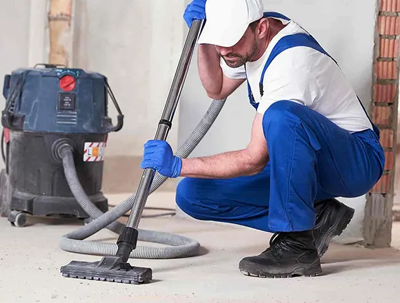 Construction cleaning professional using vacuum cleaner in a room for builder's clean services in Detroit MI.