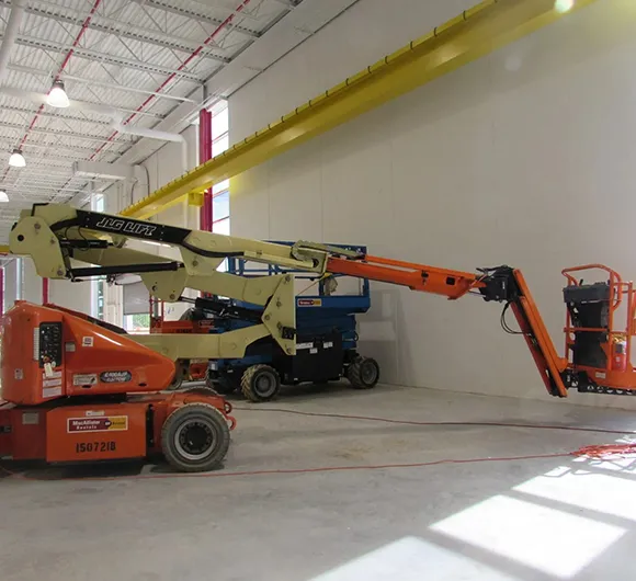 Cleaning crew with lift equipment in a large open commercial space during pre-occupancy cleaning in Kalamazoo MI.