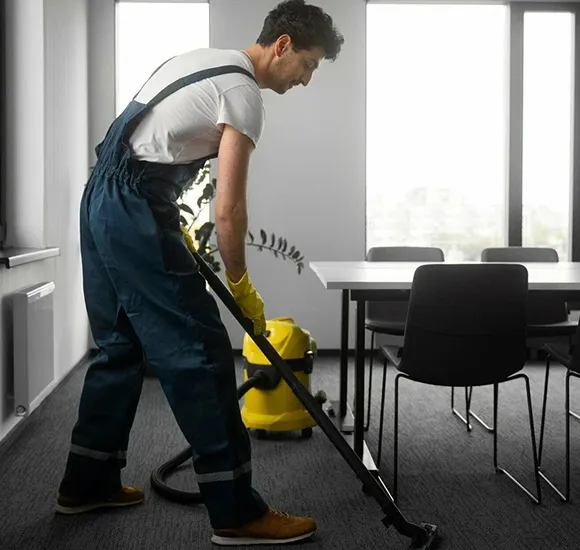 Janitorial cleaner vacuuming a carpet in an office in Lansing MI.